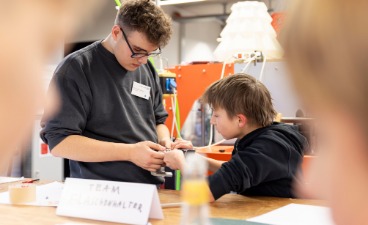 Azubi und Mittelschüler arbeiten am Prototyp Azubi und Mittelschüler arbeiten zusammen an einem Prototyp